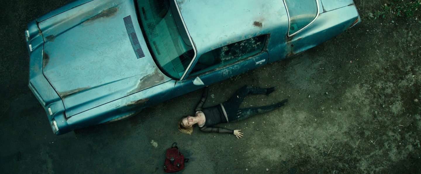 l'héroine allongé à côté d'une voiture