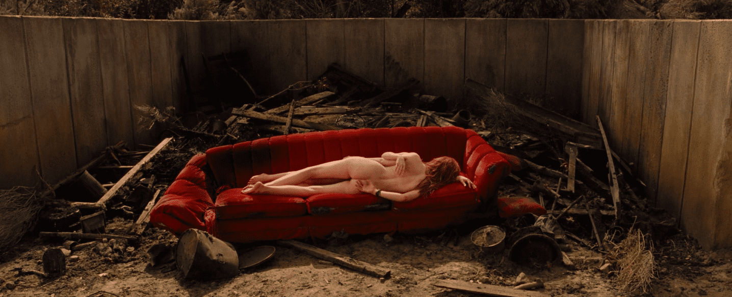 une femme nue allongé de dos sur un canapé rouge