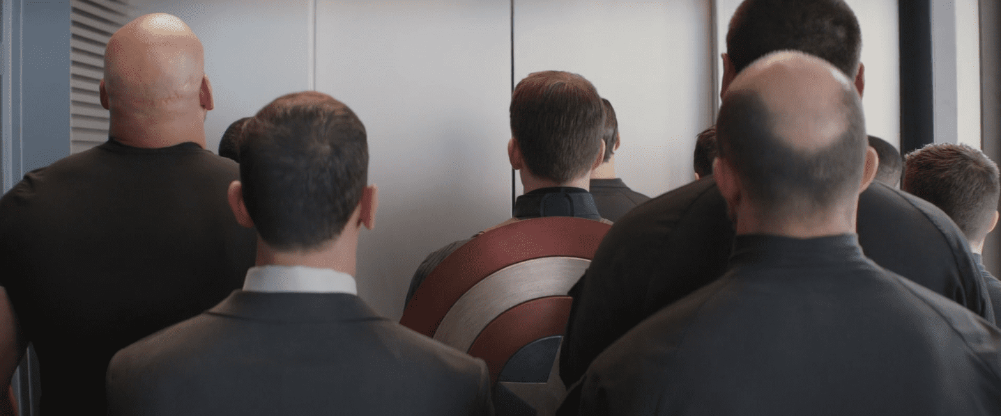 Captain America dans un ascenseur, encerclé par ses futurs aggresseurs